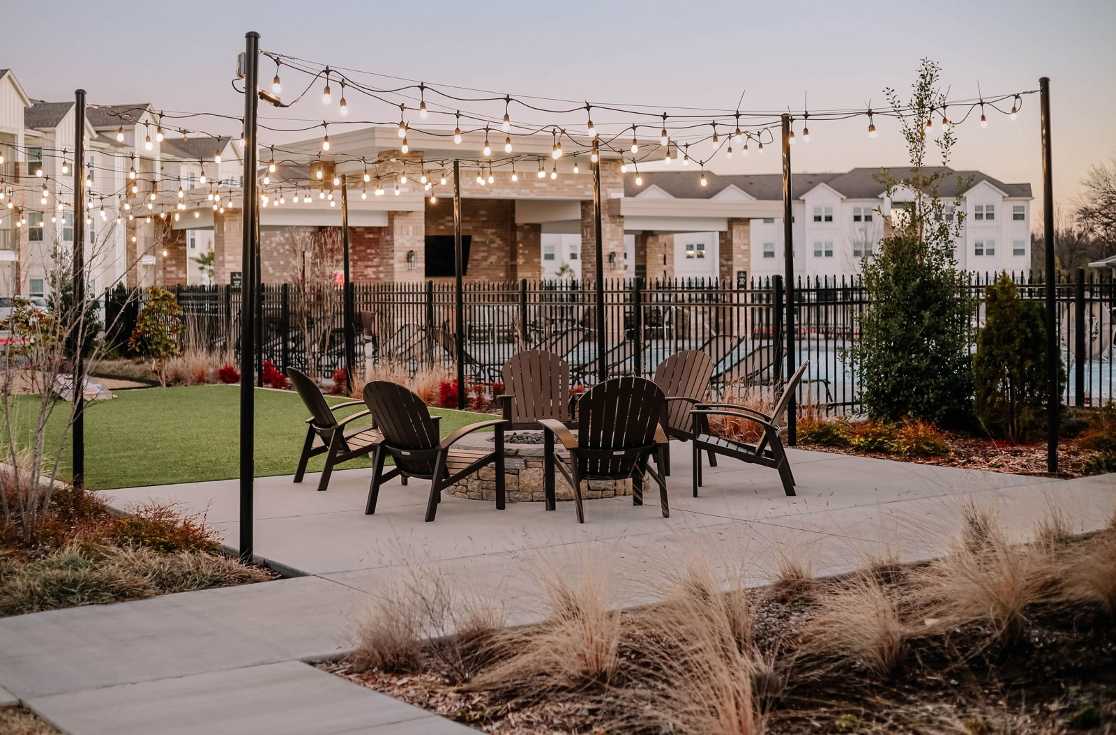 A patio seating area beneath string lights at dusk illustrates a useful lit seating zone; no pictured light is identified as a reviewed product or a verified installation.